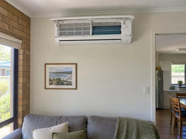 Clean split system with open front panel and visible filters on a living room wall in Salisbury North